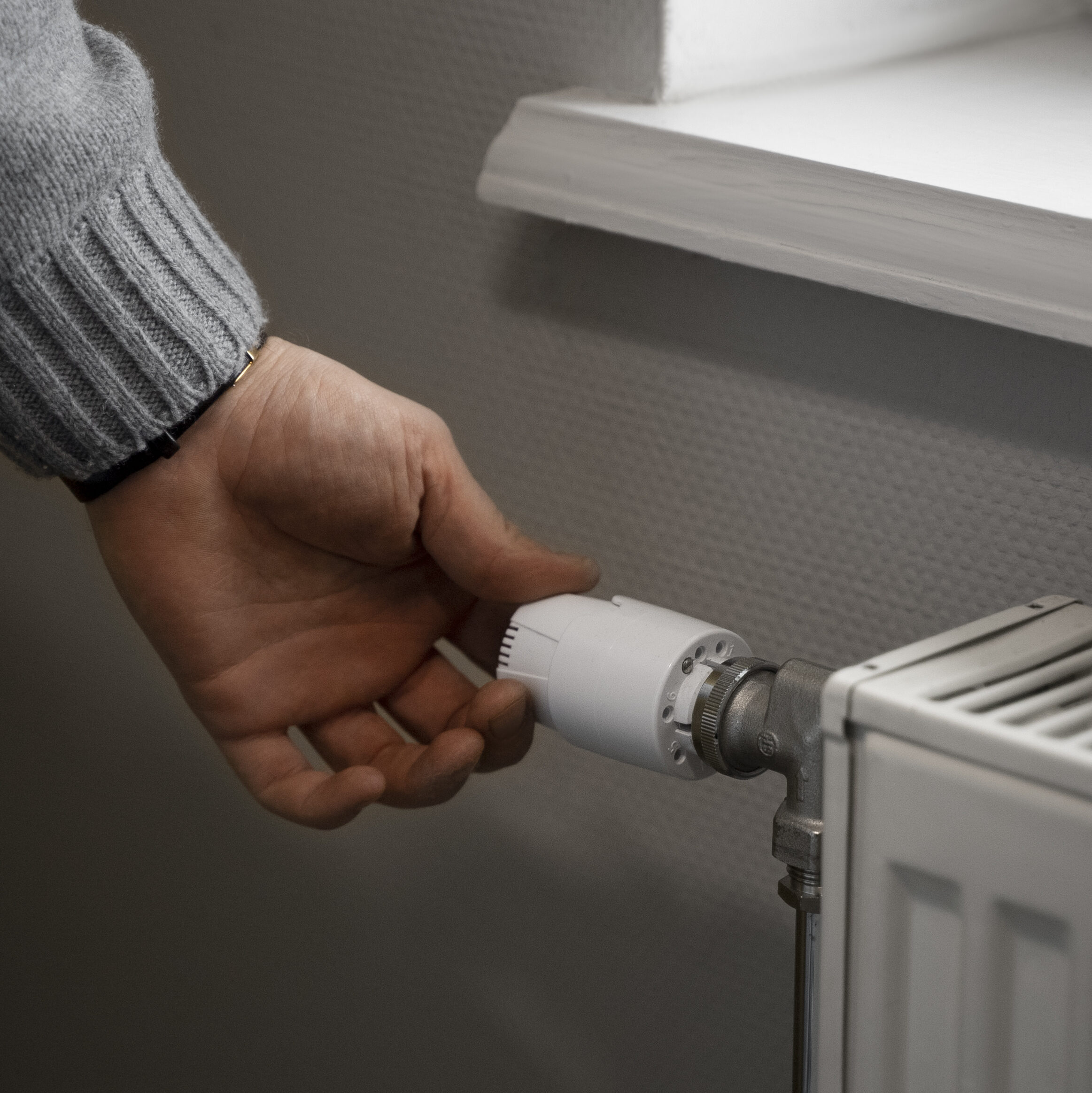 man turning dial on radiator