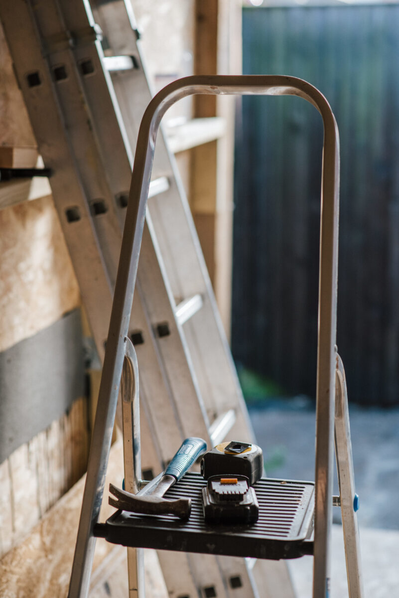 A closeup shot of a hummer and tools on the stairs during the house construction